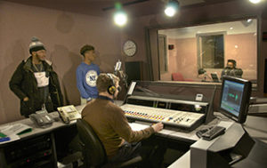Imani and Latrell watch Raymond record his part of the segment at WYPR
