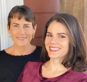 A middle-aged white woman with short brown hair, brown eyes, and a black top. To her left, a young white woman wtih the same hair and eye color and shoulder-length hair. She wears a maroon top.